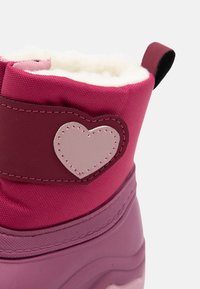 Botte imperméable rose avec un doux doublure blanche, semelle en caoutchouc et un patch décoratif en forme de cœur sur le côté dans une teinte de rose plus claire.