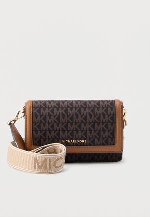 Sac bandoulière monogramme marron et noir avec une bordure en cuir, doté d'un logo doré et d'une sangle crème amovible portant le nom de la marque.