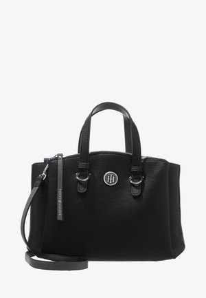 Bolso de cuero negro de Tommy Hilfiger con doble asa, correa de hombro desmontable, cierre de cremallera y emblema de logo plateado en la parte frontal.