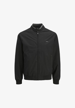 Chaqueta ligera negra con cuello alto, cremallera frontal, puños elásticos y bolsillos laterales. Textura suave y detalles de diseño mínimos.