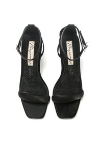 Sandali neri in suede con tacco blocco, cinturino alla caviglia regolabile, punta aperta e suola piatta, dotati di una finitura liscia e una leggera texture.