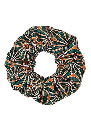 Materiałowa gumka do włosów z wyrazistym, zielonym, pomarańczowym i białym abstrakcyjnym kwiatowym wzorem ułożonym w kształt koła.