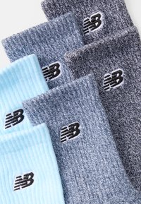 Σωρείς New Balance σε ανοιχτό μπλε, γκρι και σκούρο γκρι χρώμα. Ριχτή υφή με κεντητό λογότυπο σε κάθε κάλτσα.
