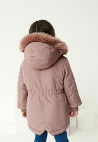 Roosa polsterdatud parka jakk vale karvaga kapuutsiga, elastse taljega ja pikade varrukatega, millel on ümar sirge ja sile tekstuur.