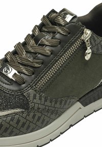 Sportovní boty tmavě zelené a černé barvy, kombinující strukturovaný semiš a vzorovanou tkaninu, s kovovými detaily a bočním zipem.