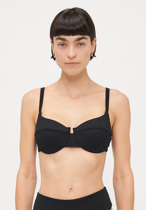 Black ribbed bikini top with underwire support, wide straps, and a center seam detail. Smooth textured fabric, minimalistic design.