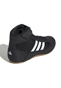 Svarta högskor med vit rand, med mesh partier, vadderad krage och gummisula för grepp.