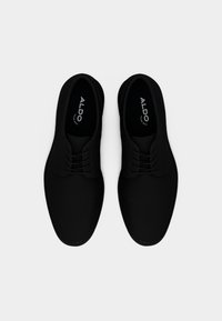 Paire de chaussures habillées noires à lacets Aldo, avec bouts arrondis, vues de dessus sur un fond blanc.