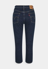 Jeans de mezclilla azul oscuro con corte recto, que cuentan con dos bolsillos traseros con un pespunte distintivo y una etiqueta de cuero en la cinturilla.