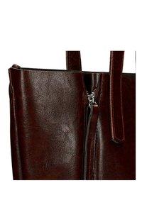 Tmavě hnědá kožená tote taška s texturovaným povrchem, vybavená zipovým uzávěrem a dvěma pevným rukojeťmi pro snadné nošení.