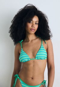 Green and blue striped bikini with triangular cups, adjustable ties at shoulders and sides, featuring a textured pattern and minimal hardware.