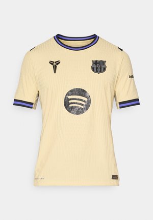 Keltainen lyhyt-hihaiseksi paita, jossa on ribbikuvio, mustat yksityiskohdat, FC Barcelonan vaakuna ja Spotify-logo edessä.