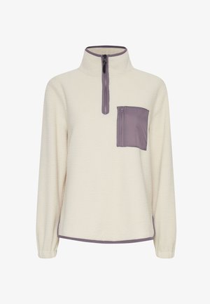 Fleece pullover in cream with a textured surface and a half-zip collar. Features a zippered pocket in purple on the left chest.