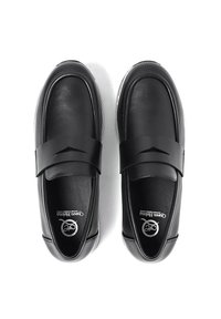 Scarpe slip-on in pelle nera con una larga fascia sul collo del piede, punta arrotondata e superficie liscia. Logo visibile all'interno della scarpa.