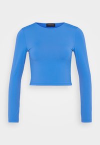 Klar blå kortærmet bluse med rund halsudskæring og tætsiddende silhuet, vist mod en ensfarvet hvid baggrund.