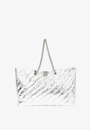 Sac cabas matelassé argenté brillant avec poignées en chaîne métallique et petit logo métallique "B" en haut au centre.