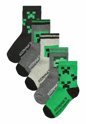 Set von fünf Socken in einer Kombination aus Schwarz, Grau und Grün. Jede Socke hat pixelierte Muster, die einem Charakter ähneln. Material aus Baumwollmischung.