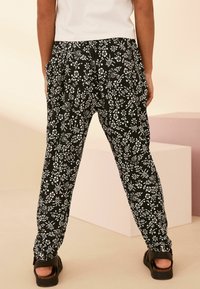 Next - REGULAR FIT - Stoffhose - black  white floral print Thumbnail-Bild 1