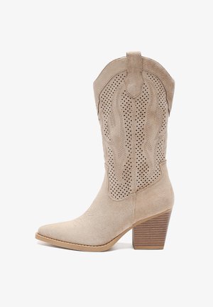 Beżowe zamszowe kowbojki z wąskim czubkiem, dekoracyjnymi wycięciami i profilowaną piętą. Posiadają strukturalny wzór na cholewie i gładką podeszwę.