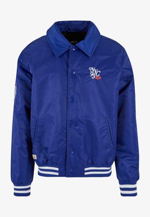 Chaqueta bomber azul con un acabado brillante, puños y dobladillo con rayas blancas, botones a presión y diseño bordado de Nueva York en el pecho y la manga.