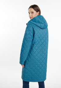 Teal quilted frakke med hætte, diamantmønster og længere snit, lavet af et glat, let materiale.