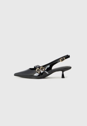 Sort laklæder slingback pumps med kitten heel, spids tå og to guld spænder hen over toppen.