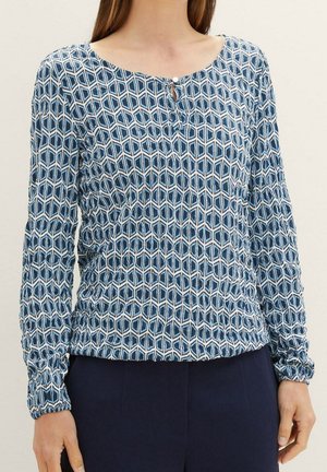 Bluzka z długim rękawem wykonana z lekkiego materiału, z niebieskim geometrycznym wzorem, dekoltem w kształcie litery U z detalem na guziki oraz marszczonymi mankietami.