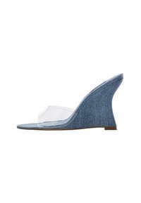 Sandalo con zeppa in denim, dotato di una fibbia in vinile trasparente. Presenta un tacco a zeppa alto e curvo e una tomaia in denim blu texturizzato.