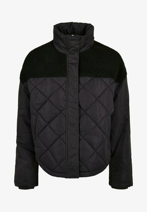 Oliwkowa pikowana kurtka z futrzanym kołnierzem, z zamkiem błyskawicznym i napami, zestawiona z czarnymi legginsami.