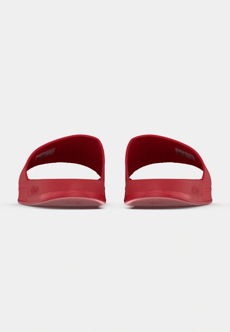 Røde slip-on sandaler med et åbent design, glat gummimateriale og tekstureret sål. Har en bred tååbning og minimalistisk branding.