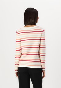 Striped long-sleeve sweater with a round neckline, featuring alternating shades of pink, red, and cream on a textured fabric.