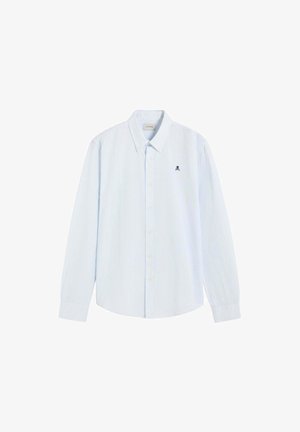 Camisa azul claro de manga larga con botones, con sutiles rayas verticales y un pequeño logo negro de calavera en el pecho izquierdo.