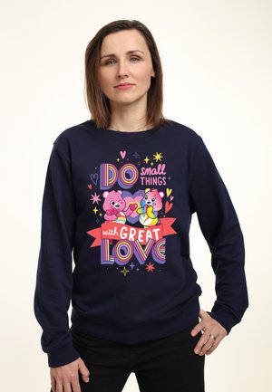 Navy sweatshirt med farverigt grafik med to tegneserie-bjørne og teksten "Gør små ting med STOR KÆRLIGHED." Blødt stof, afslappet pasform.