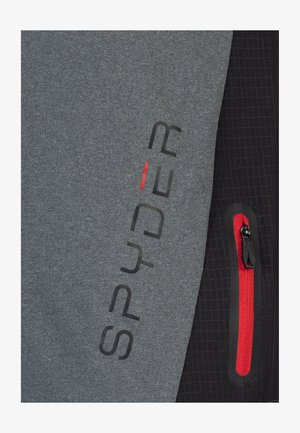 Grijze en zwarte jas met een gladde textuur, een rode ritszak en een opvallend "SPYDER" logo met rode accenten.