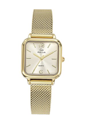 Montre carrée ton or avec bracelet en maille, cadran minimaliste affichant 10h10, et texte "Go Mademoiselle Quartz" sur le cadran.