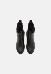 Zwarte leren enkellaarsjes met een gladde afwerking, elastische zijpanelen, aantreklussen en ronde neuzen. Voorzien van een lage gestapelde hak.