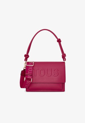 Sac à main en cuir magenta avec logo "TOUS" embossé, anse supérieure nouée et une bandoulière avec un logo répété dans une teinte plus claire.