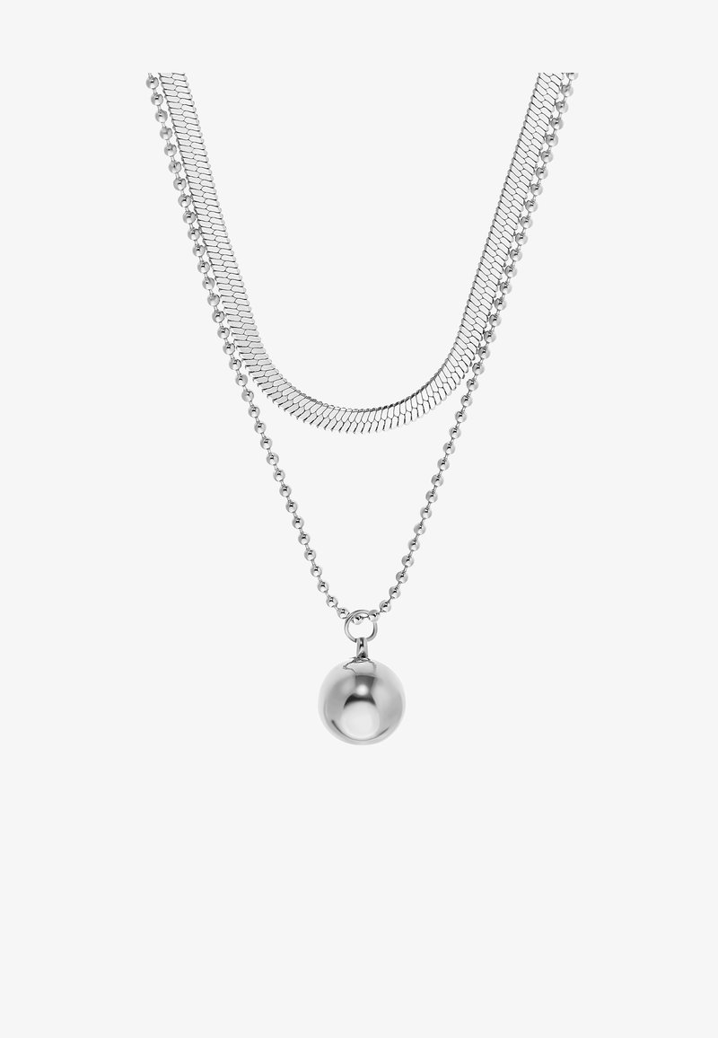Deux colliers argentés superposés, l’un avec une chaîne en arête de poisson et l’autre avec une chaîne perlée tenant un pendentif boule en argent brillant.