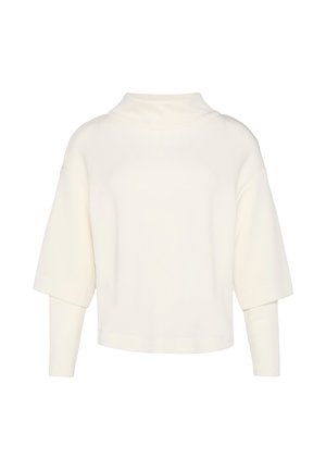Haut à manches courtes et col montant en tissu blanc doux avec une coupe oversize. Présente des poignets roulés et une texture lisse et dépouillée.