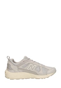 Baskets de sport gris clair avec panneaux en mesh et daim, semelle épaisse beige, lacets et un logo "N" bien visible sur le côté.