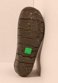 Suela de goma marrón con ranuras texturizadas, que presenta un logo de rana verde y "EL NATURALISTA" grabado. Salpicada de partículas de colores.