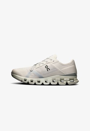 Weiße Sportschuh mit einem atmungsaktiven Mesh-Obermaterial, grauen Akzenten, einer gepolsterten Sohle und einem auffälligen segmentierten Außensohlen-Design.