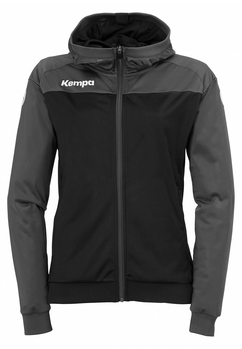 Giacca con cappuccio nera e grigia scura, con zip frontale, polsini elastici e logo "Kempa" sul petto, realizzata in un materiale liscio e leggero.