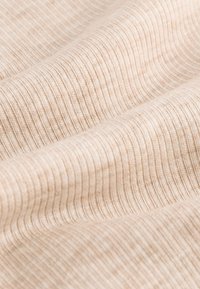 Beżowa, teksturowana tkanina z delikatnymi poziomymi prążkami, zapewniająca miękki i gładki wygląd z subtelnym połyskiem.