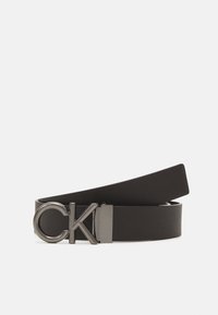 Black leather belt featuring a metal CK logo buckle. The belt has a smooth texture and a sleek, minimalist design.