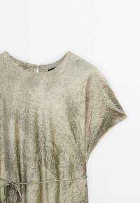 Robe beige froissée avec un col rond, des manches courtes et une ceinture nouée à la taille. Tissu texturé avec une légère brillance.