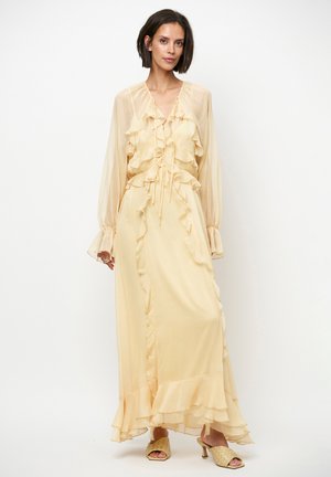 Lange, lichtgele jurk van lichtgewicht stof met franjes, lange doorschijnende mouwen en een vloeiende zoom met een gelaagd ontwerp.