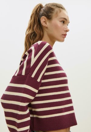 Weinrot- und cremefarbener gestreifter Pullover mit lässiger Passform, geripptem Saum und weiten Ärmeln. Hergestellt aus einem weichen Strickmaterial.