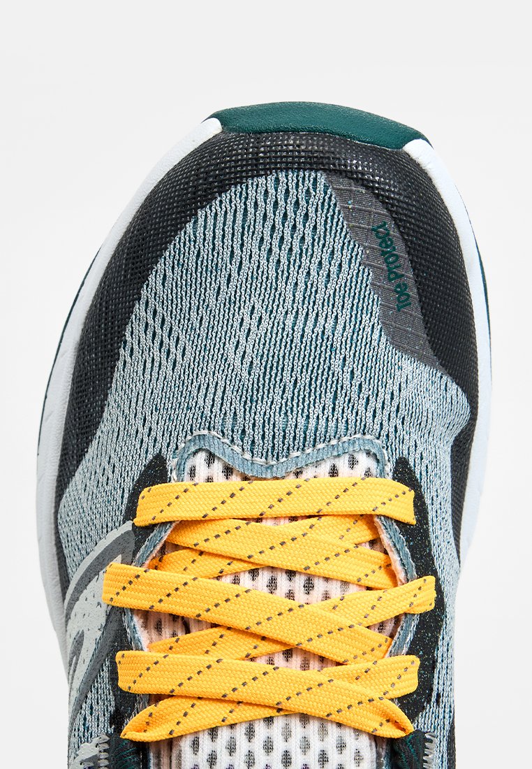 Sportlicher Sneaker mit Nahaufnahme der Zehenpartie, grauem Mesh-Obermaterial, schwarzen und teal-farbenen Akzenten sowie gelben Schnürsenkeln, die in einem standardmäßigen überkreuzten Muster gebunden sind.