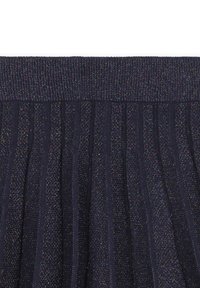 Gonna plissettata blu navy in tessuto testurizzato con filo metallizzato, che crea un delicato luccichio. Vita elasticizzata per comfort e vestibilità.